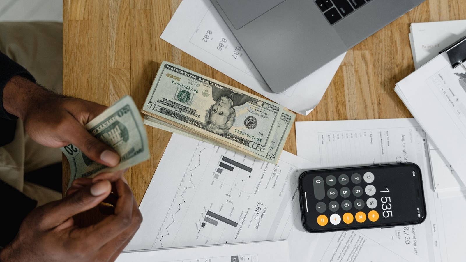 Calculator, cash and paperwork on a desk while planning a budget